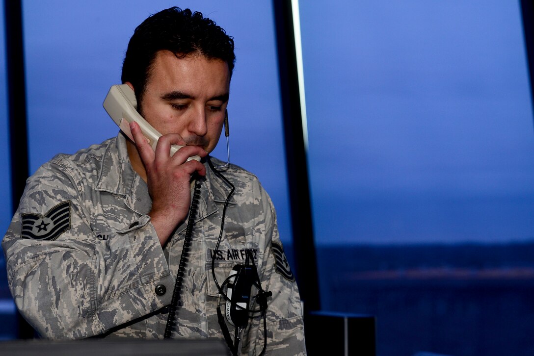 U.S. Air Force Tech. Sgt. Mark Chavez, 1st Operations Support Squadron air traffic controller, confirms weather changes in the control tower at Langley Air Force, Va., Nov. 4, 2015. Air traffic controls Airmen approve flight plans, ensure takeoff and landing safety and direct air traffic, for all aircraft working with the airfield. (U.S. Air Force photos by Airman 1st Class Derek Seifert/ Released)