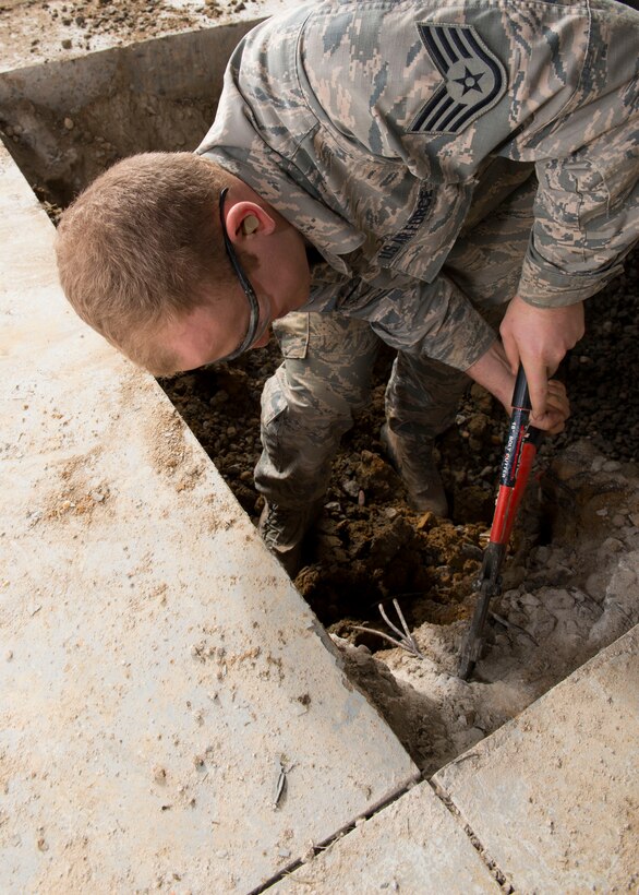 U.S. Air Force Staff Sgt. Kenneth Conrad, 633rd Civil Engineer Squadron water and fuel systems maintenance technician, uses bolt cutters to remove metal reinforcement mesh at Langley Air Force Base, Va., Nov.6, 2015. During the repairs, the water and fuels system maintenance shop’s mission was to repair two 12-foot water lines. (U.S. Air Force photo by Staff Sgt. John D. Strong II/Released)