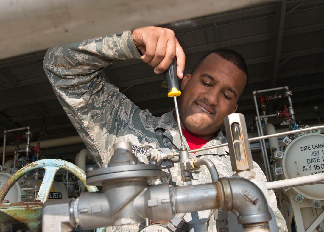 U.S. Air Force Airman 1st Class Joshuea Bryant-Thomas, 633rd Civil Engineer Squadron water and fuel systems maintenance technician, adjusts the opening speed on a back pressure control valve in the pump house at Langley Air Force Base, Va., Nov.6, 2015.  The pump house distributes Jet-A fuel to be pumped underground to the flight line. (U.S. Air Force photo by Staff Sgt. John D. Strong II/Released)