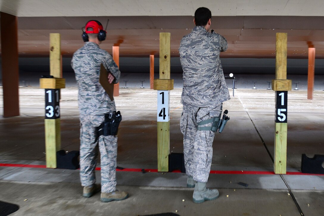 U.S. Air Force Master Sgt. Chad Carver, 633rd Security Forces Squadron Standardization and Evaluation chief, right, shoots a Berretta M9 pistol at Langley Air Force Base, Va., Nov. 5, 2015. The SFS Airmen took part in a shooting competition as a way to stay proficient, build confidence and master the task of marksmanship. (U.S. Air Force photo by Senior Airman Kimberly Nagle/Released) 