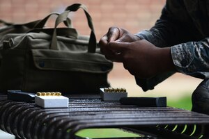 A U.S. Airman assigned to the 633rd Security Forces Squadron loads a Berretta M9 pistol magazine at Langley Air Force Base, Va., Nov. 5, 2015. Each SFS member who participated in the squadron’s Comprehensive Airmen Fitness day shoot-off were given a total of 30 rounds, 15 for each magazine for the competition. (U.S. Air Force photo by Senior Airman Kimberly Nagle/Released)