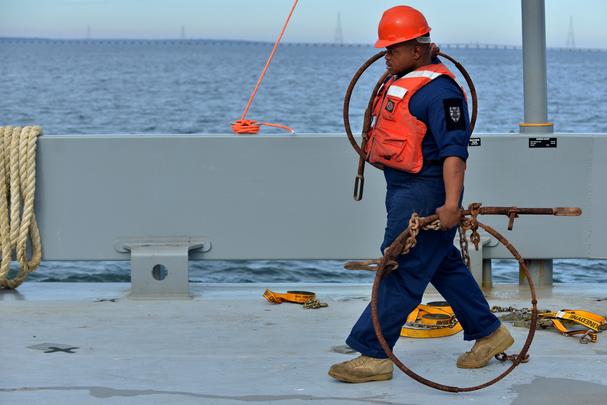 U.S. Army Sgt. Kadeem Johnson, 97th Transportation Company leading seaman, moves tie down straps and vehicle lashings to a load-on and load-off training staging area on the James River in Newport News, Va., Nov. 3, 2015. The equipment was used to securely tie down vehicles weighing more than 50,000 pounds. (U.S. Air Force photo by Staff Sgt. Natasha Stannard/Released)