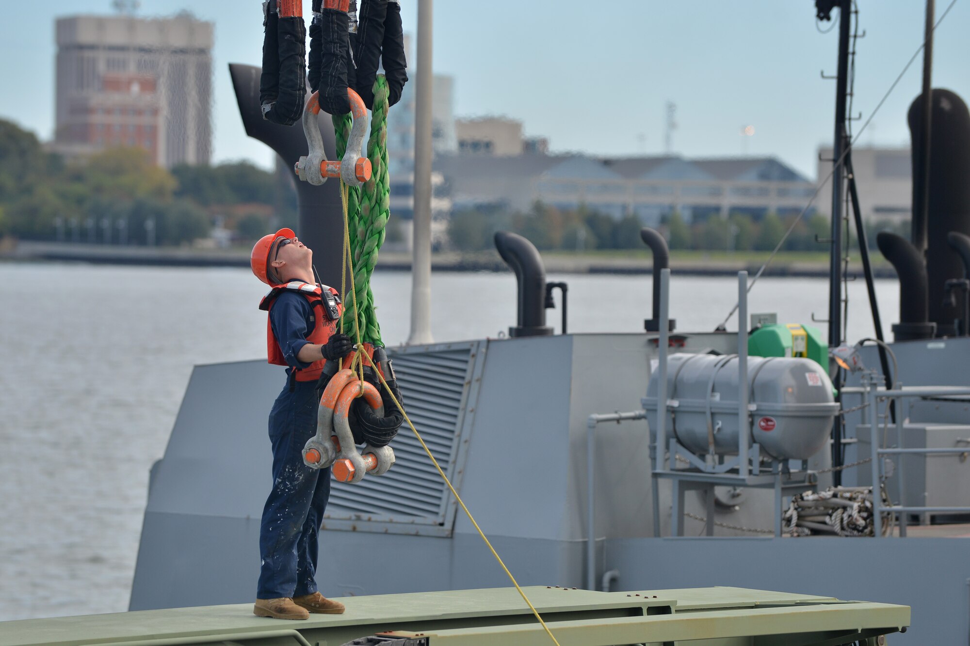 U.S. Army Spc. Koe Fields, 73rd Transportation Company floating craft seaman, gathers a barge crane’s ropes to attach to a Kalmar rough terrain container handler during a training exercise on the James River in Newport News, Va., Nov. 3, 2015.  The exercise involved transferring two Kalmar’s and two forklifts from a barge crane to the 97th Transportation Company’s Vessel Brandy Station. (U.S. Air Force photo by Staff Sgt. Natasha Stannard/Released)