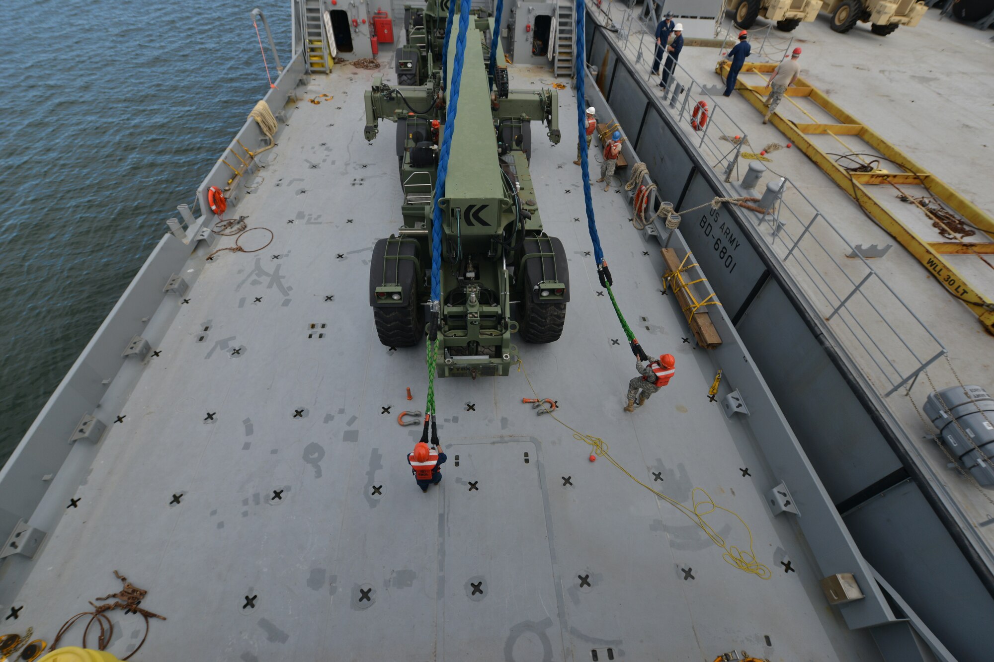 Crew members of the U.S. Army Vessel Brandy Station assigned to 97th Transportation Company remove a barge crane’s ropes from a Kalmar rough terrain container handler on the James River in Newport News, Va., Nov. 3, 2015. The Brandy Station crew and 73rd Transportation Company Soldiers moved the Kalmar along with three other vehicles as part of a load-on and load-off training exercise. (U.S. Air Force photo by Staff Sgt. Natasha Stannard/Released)