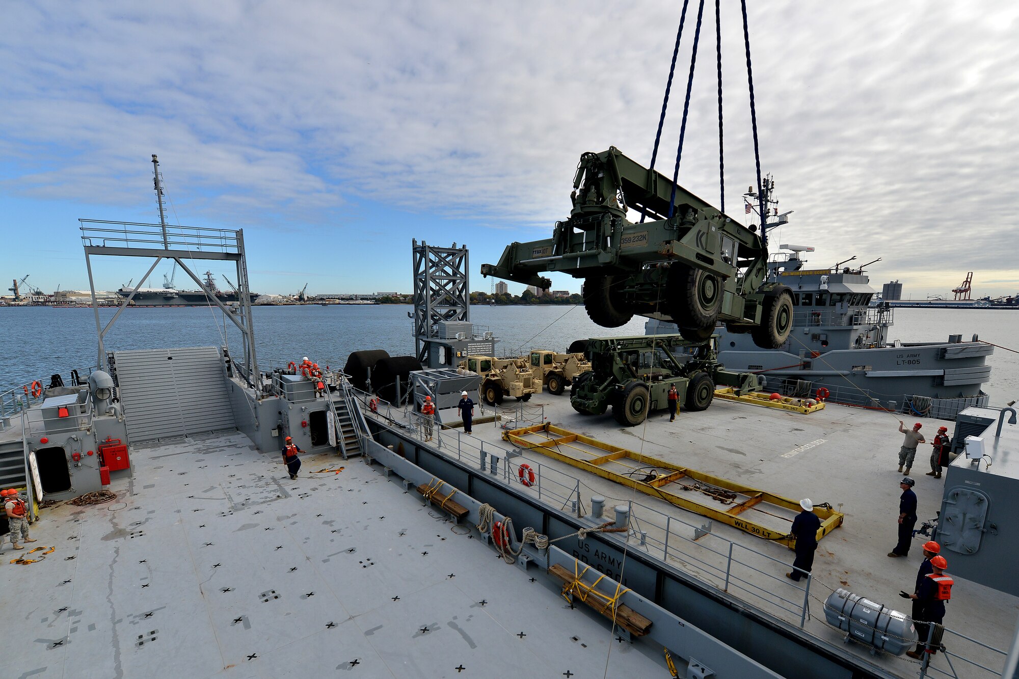 U.S. Army Vessel Brandy Station crew members assigned to 97th Transportation Company and 73rd Trans. Co. Soldiers work together to load a Kalmar rough terrain container handler onto the Brandy Station using a barge crane on the James River in Newport News, Va., Nov. 3, 2015. The training was conducted in preparation for any missions either unit may encounter during contingency operations around the world’s coastal waterways. (U.S. Air Force photo by Staff Sgt. Natasha Stannard/Released)