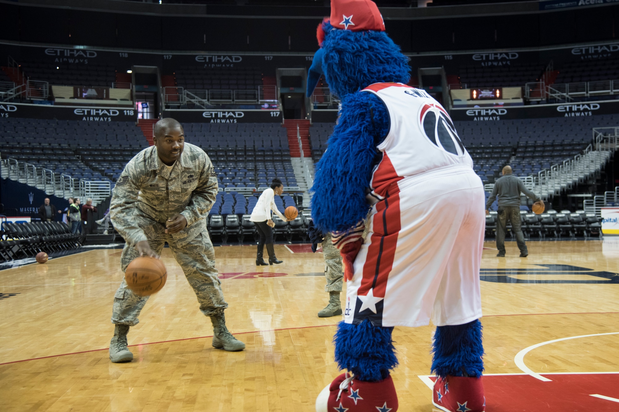 Tech. Sgt. Thomas White, Air Force District of Washington unit training manager, plays one-on-one with G-Wiz, Washington Wizards mascot, on the court of the Washington Wizards after a Salute to the Stars event at the Verizon Center in Washington, D.C., Nov. 9, 2015. The event included watching the team’s practice, a player meet-and-greet and bagging food for homeless military veterans. (U.S. Air Force photo by Airman 1st Class Philip Bryant/Released)