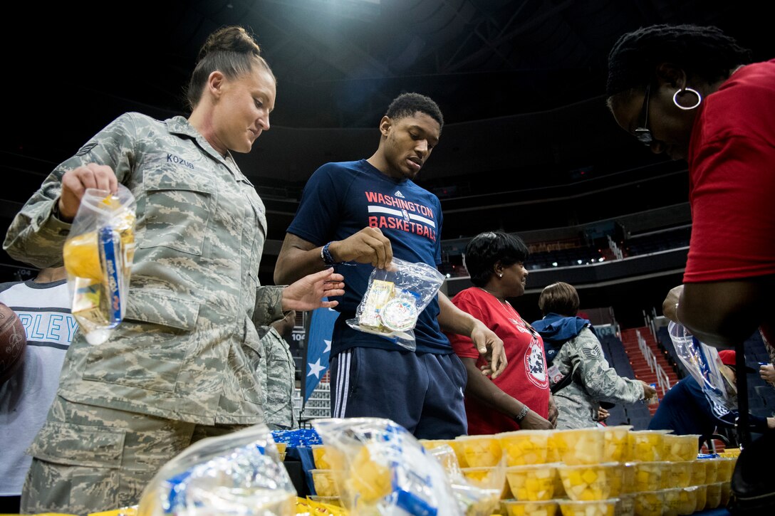 Staff Sgt. Jillian Kozub, 79th Medical Wing member, bags up food with Bradley Beal, Washington Wizards shooting guard, during a Salute to the Stars event at the Verizon Center in Washington, D.C., Nov. 9, 2015. Salute to the Stars is an annual event held by the Wizards that included bagging food for homeless military veterans. (U.S. Air Force photo by Airman 1st Class Philip Bryant/Released)