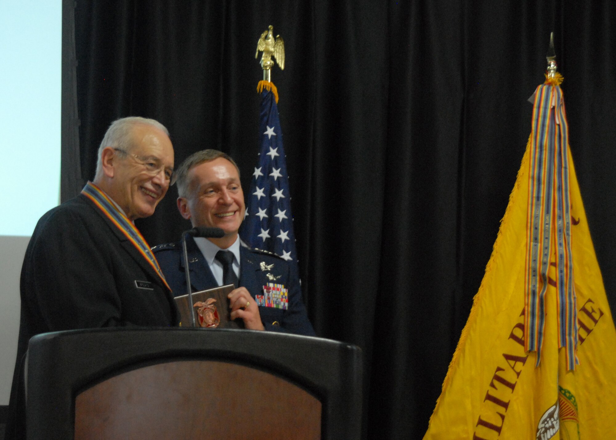 Joseph Brocato, Past Commander, The General Hoyt S. Vandenberg Chapter of the Military Order of the World Wars, present a plaque to Lt. Gen. David Buck, 14th Air Force (Air Forces Strategic) and Joint Functional Component Command for Space Commander, in appreciation for his participation in an event honoring World War II and Korean War Veterans, Oct. 29, 2015 at the Alex Madonna Expo Center in San Luis Obispo, Calif.  Buck spoke to a room of more than 600 veterans, their families and friends, expressing his sincere gratitude for their service and the legacy of honor and valor they have bestowed upon all those who serve today. (U.S. Air Force photo by Capt. Nicholas Mercurio/Released)