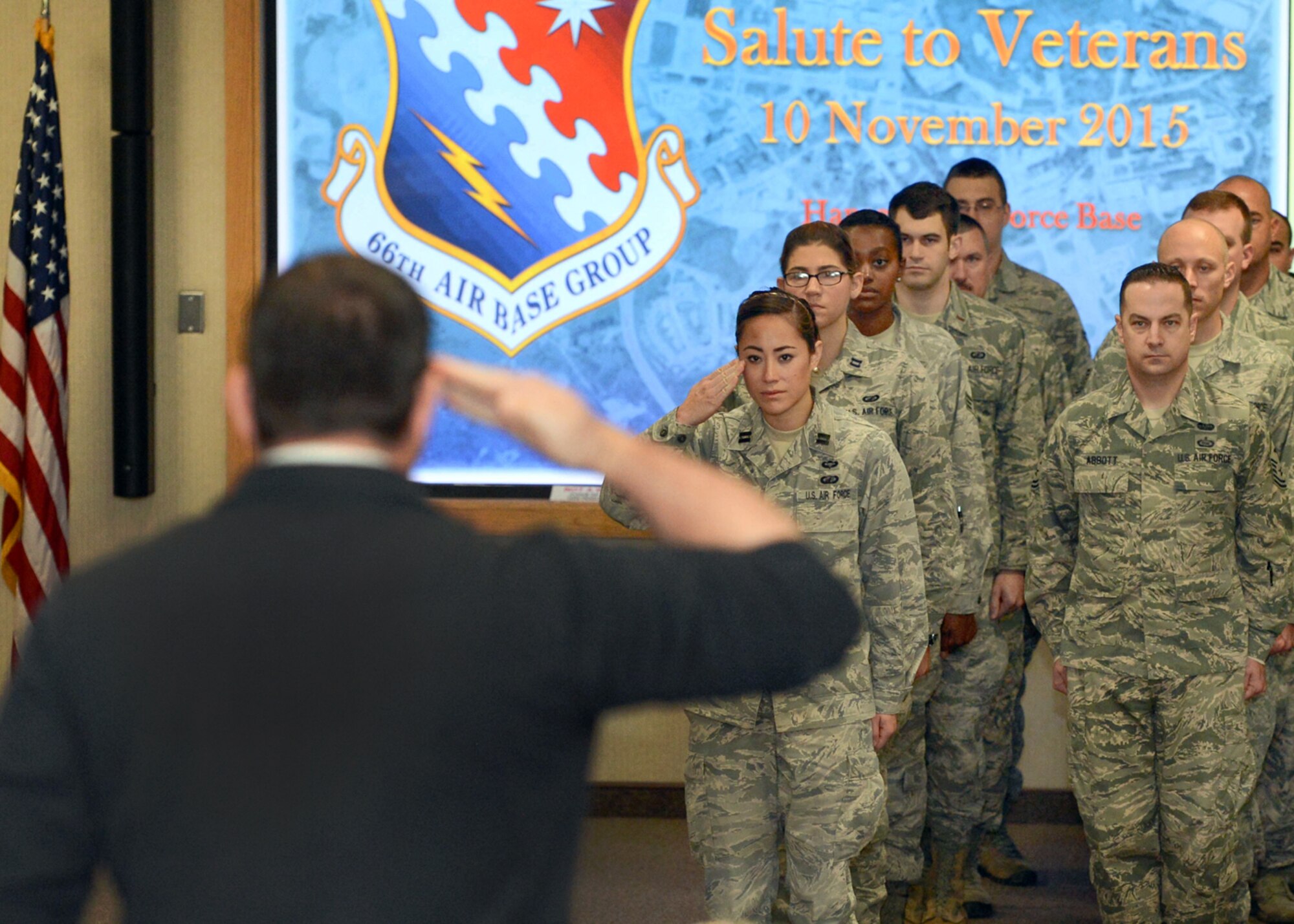 A veteran in the audience returns a salute from Capt. Samantha Sarkis, 319th Recruiting Squadron Operations Flight commander, after his name is called during the 4th Annual Salute to Veterans at the Hanscom Conference Center Nov. 10. The base held the ceremony to recognize and thank local veterans for their service to the nation. Veterans from World War II to the current campaigns in Iraq and Afghanistan attended the event. (U.S. Air Force photo by Jerry Saslav)