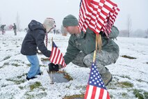 Staff Sgt. Louis Hurst and son, Ethan, place a flag beside a burial site at the Utah Veterans Memorial Cemetery, Bluffdale, Utah, Nov. 10, 2015. Over 100 Team Hill Airmen participated in the flag-placing detail organized by the Air Force Sergeants Association Chapter 1163. (U.S. Air Force photo by R. Nial Bradshaw/Released)