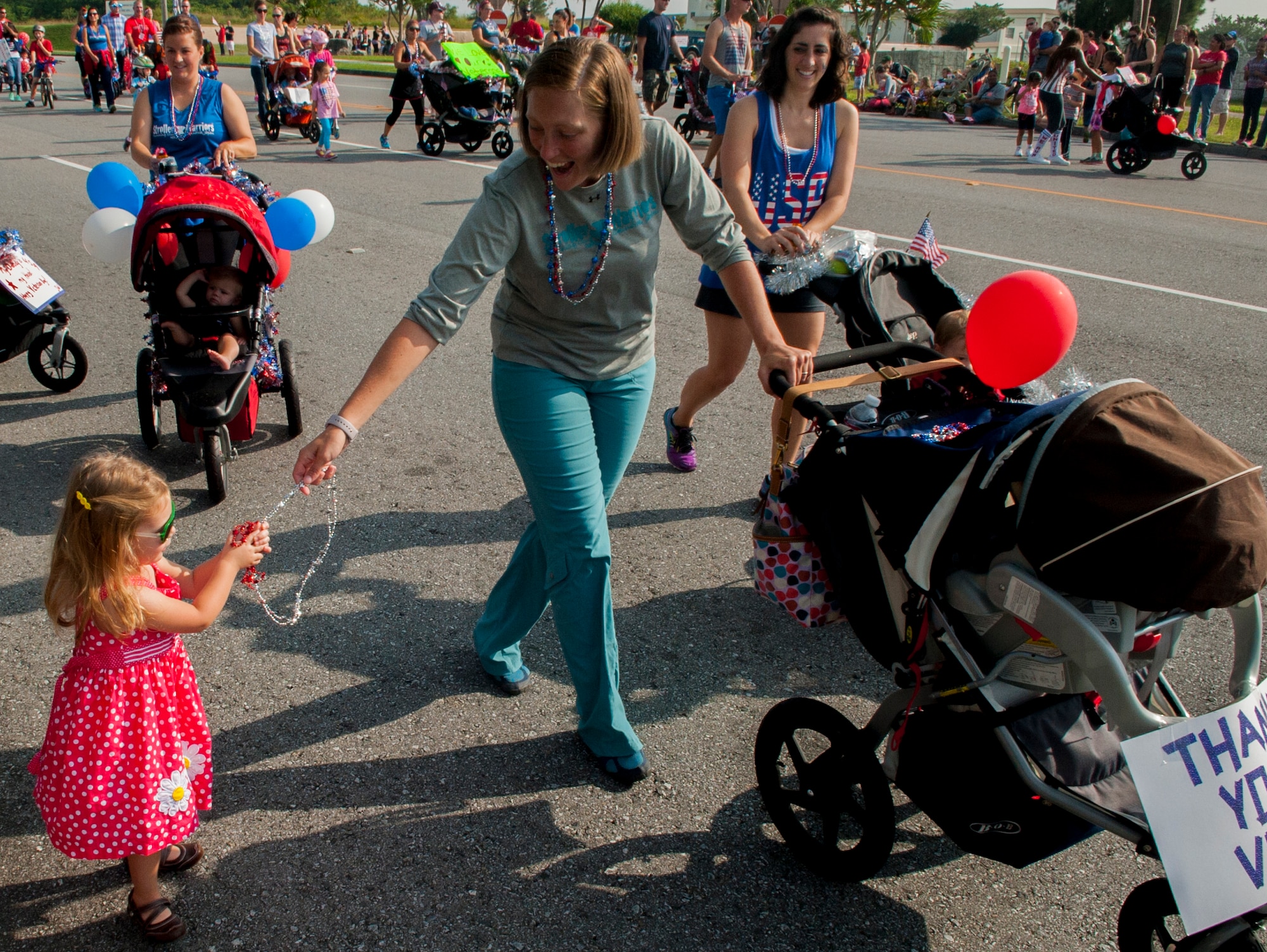 Team Kadena's Stroller Warriors hand out candy and bead necklaces during the Veterans Day parade Nov. 11, 2015, at Kadena Air Base, Japan. Veterans Day is observed annually on November 11 to preserve the historical significance of the date and to honor all of America's veterans. (U.S. Air Force photo by Airman 1st Class Nicholas Emerick)

