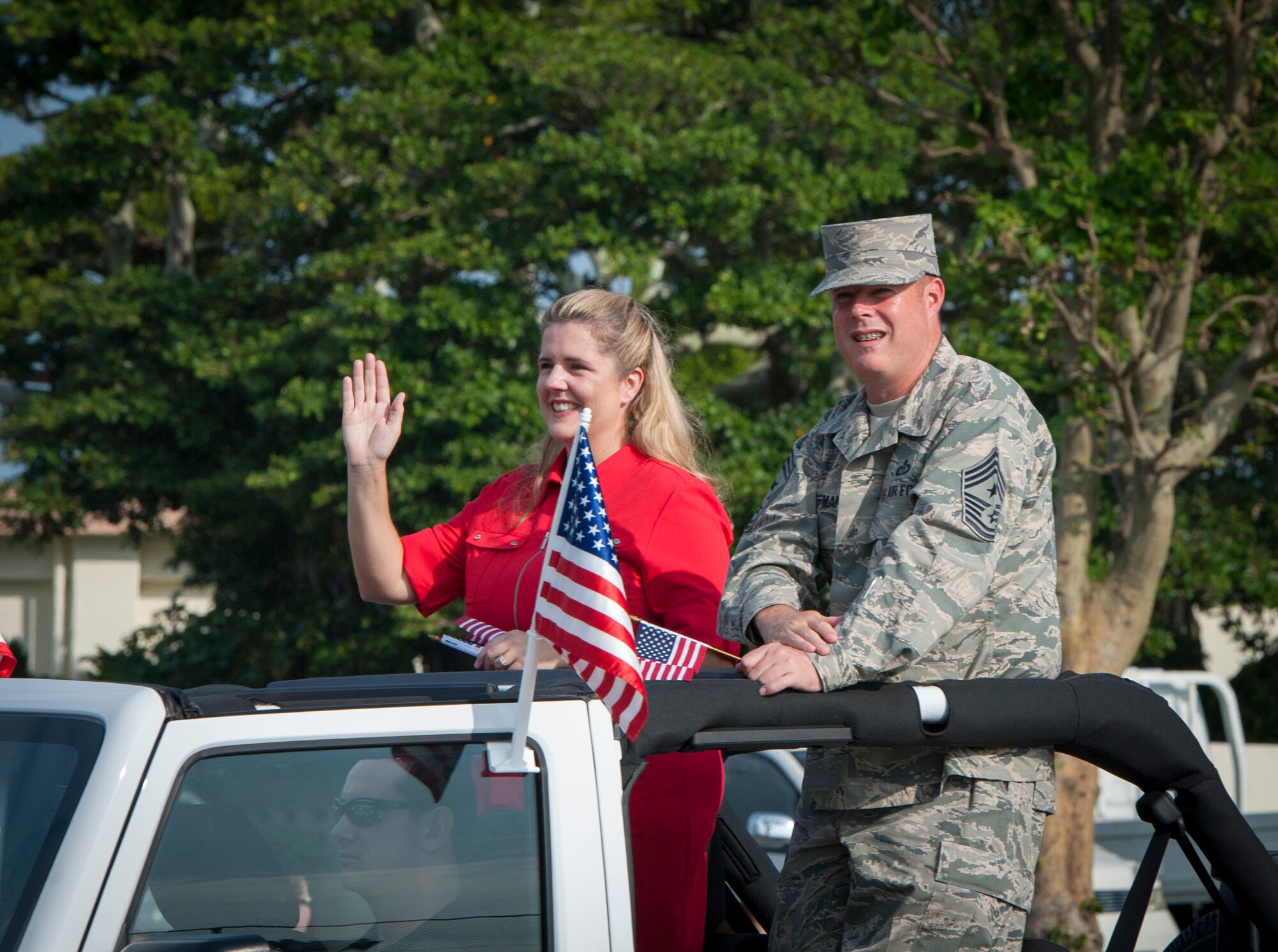 U.S. Air Force Chief Master Sgt. Charles Hoffman, 18th Wing command chief, and wife, Sabrina, wave to attendees of Kadena's first Veterans Day parade Nov. 11, 2015, at Kadena Air Base, Japan. Veterans Day is observed annually on November 11 to preserve the historical significance of the date and to honor all of America's veterans. (U.S. Air Force photo by Master Sgt. Jason W. Edwards)
