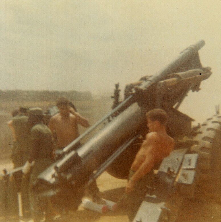 Carl Falk was a soldier in the US Army and served in the field artillery in South Vietnam.  He is pictured here, at the right, pulling the lanyard on a M114 155mm howitzer with a charge 7 shot.  That was seven powder bags to fire the shell, a maximum propelling charge on the weapon.  (Courtesy Carl Falk)