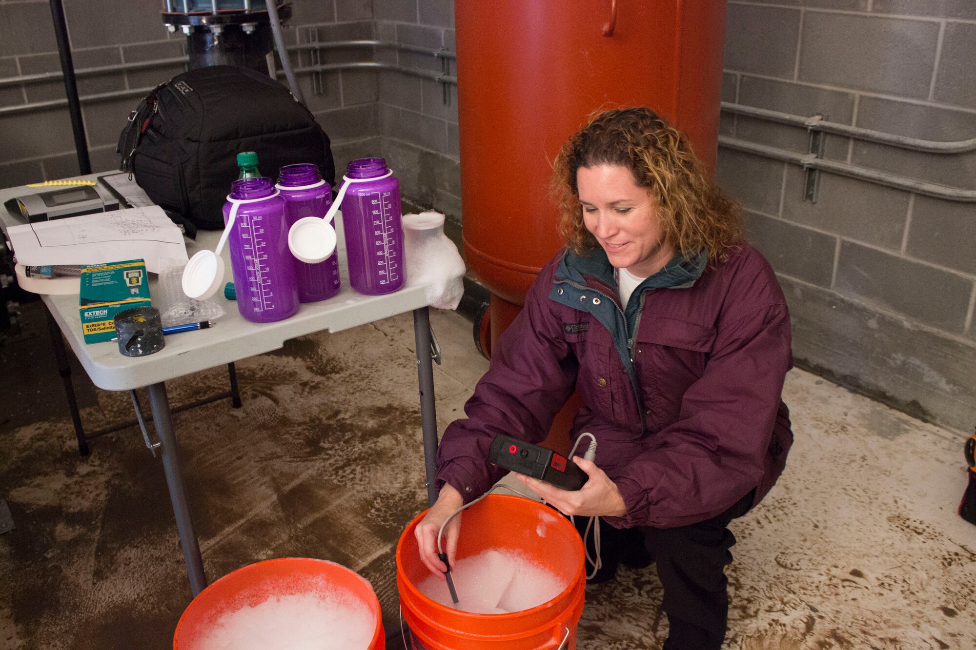 Judy Biddle, the hangar fire suppression subject matter specialist at the Air Force Civil Engineer Center at Tyndall Air Force Base, Florida, tests the foam concentrate solution for accuracy percentage during final acceptance test, or FAT, commissioning of hangar fire suppression systems at Hill Air Force Base, Utah. (U.S. Air Force Photo/Susan Lawson/Released)
