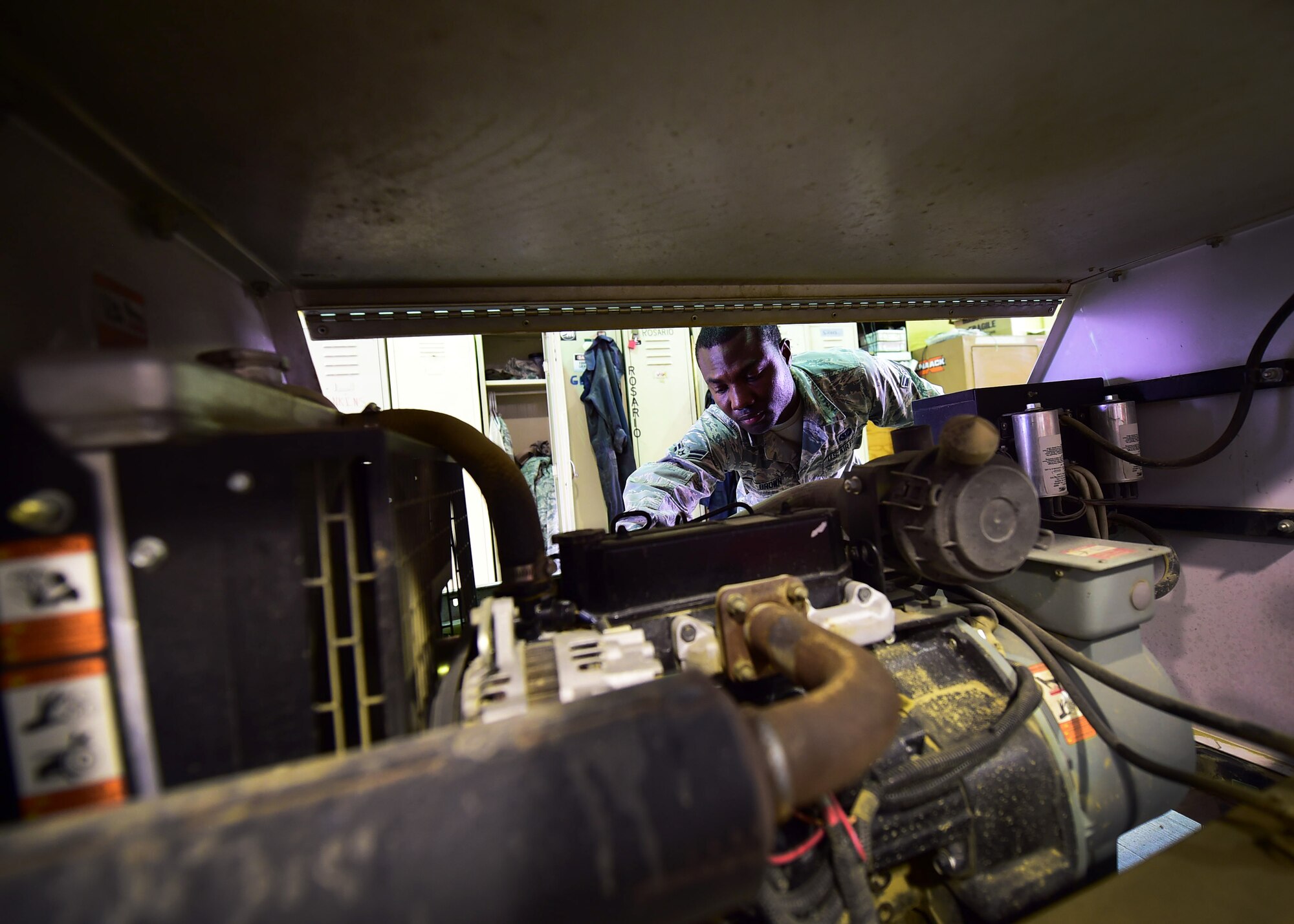 Airman 1st Class Timouy Brown, a 386th Expeditionary Civil Engineer Squadron electrical power production journeyman, inspects a light cart motor at an undisclosed location in Southwest Asia, Nov. 6, 2015. The power production shop services and maintains light carts which provides additional lighting throughout the installation and is convenient and mobile. Brown is deployed from the 319th Civil Engineer Squadron, Grand Forks Air Force Base in North Dakota. (U.S. Air Force photo by Staff Sgt. Jerilyn Quintanilla