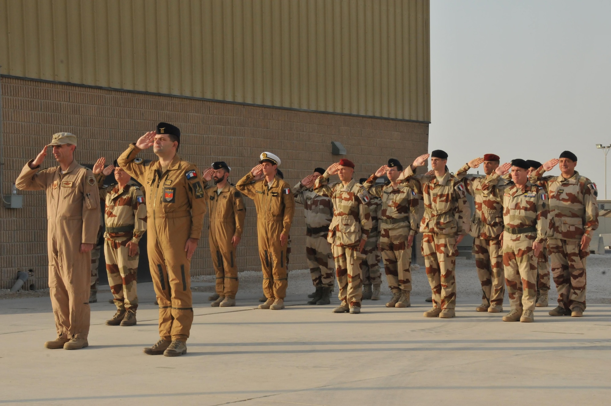 French and other coalition members render a salute to commemorate the raising of the French flag at Al Udeid Air Base, Qatar. Armistice Day was declared in 1938 after the Great War. (U.S. Air Force photo by Tech. Sgt. Terrica Y. Jones/released)