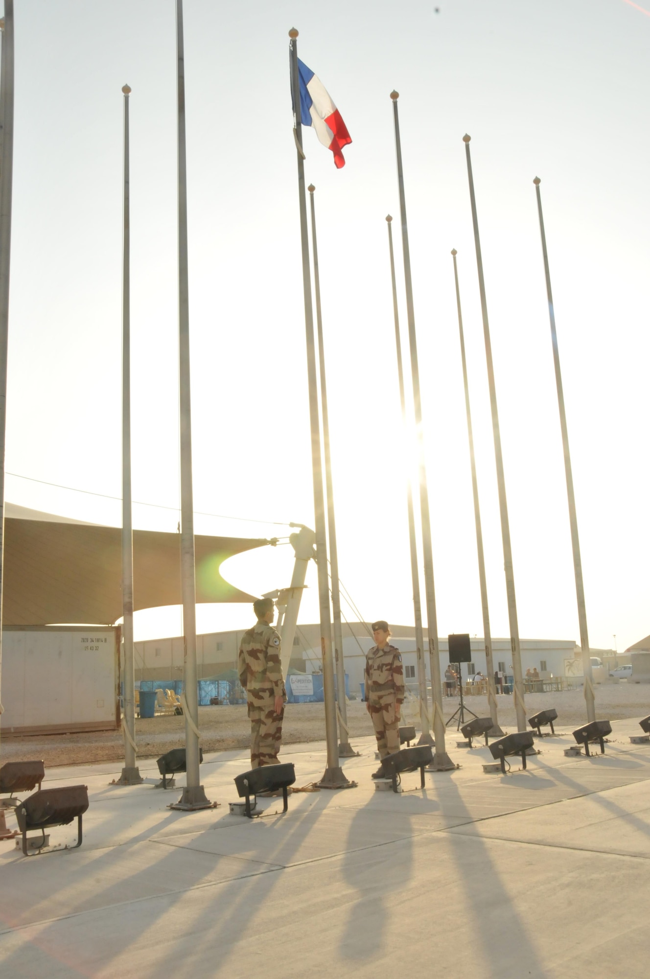 Service members pay honor and tribute to the past service members Nov. 11 as the French flag is raised at Al Udeid Air Base, Qatar. French soldiers alongside other services came out to pay their respect. (U.S. Air Force photo by Tech. Sgt. Terrica Y. Jones/released)