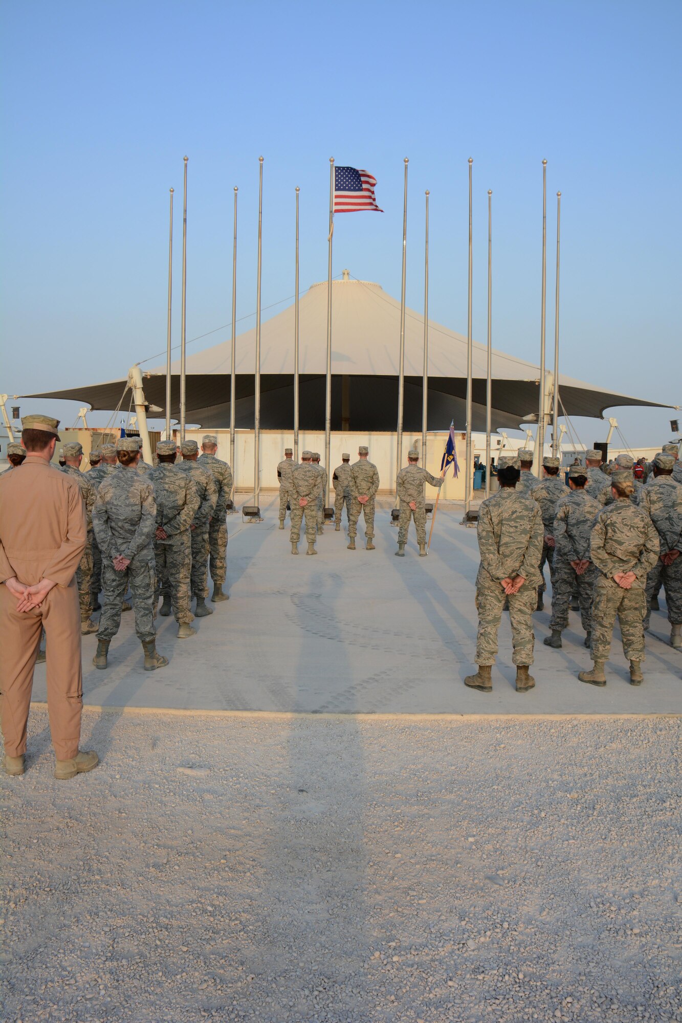 Hundreds of service members from Al Udeid Air Base, Qatar stand in formation Nov. 11 as they wait for the U.S. flag to be lowered during a retreat ceremony at the base in observance of Veterans Day. The retreat ceremony was held to honor America's veterans past and present. (U.S. Air Force photo by Tech. Sgt. James Hodgman/Released)
