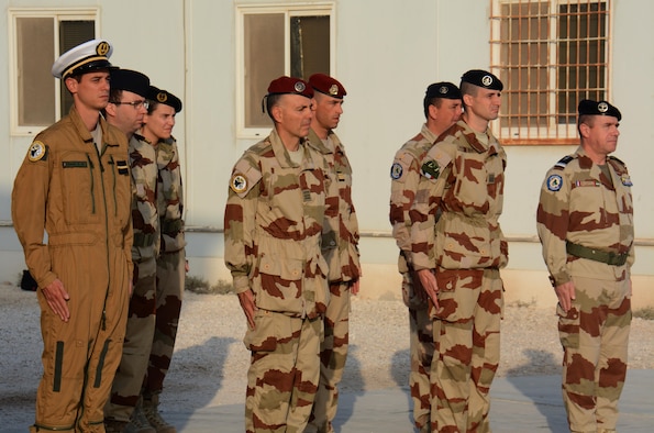 Service members stand in formation during a flag raising ceremony to honor past service members Nov. 11 as the French flag is raised at Al Udeid Air Base, Qatar. French soldiers alongside service members from other nations gathered to commemorate the end of World War I, known in Europe as Armistice Day. (U.S. Air Force photo by Tech. Sgt. James Hodgman/Released)