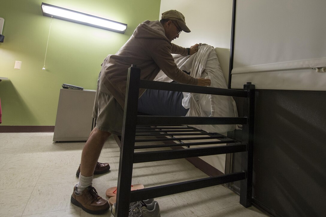 Army veteran Manuel “Al” Alcantara shows how he ties his sheets under his mattress as a means to deal with night terrors in his room at the post-traumatic stress disorder clinic at Bay Pines Veterans Affairs Medical Center in Bay Pines, Fla. Oct. 28, 2015.