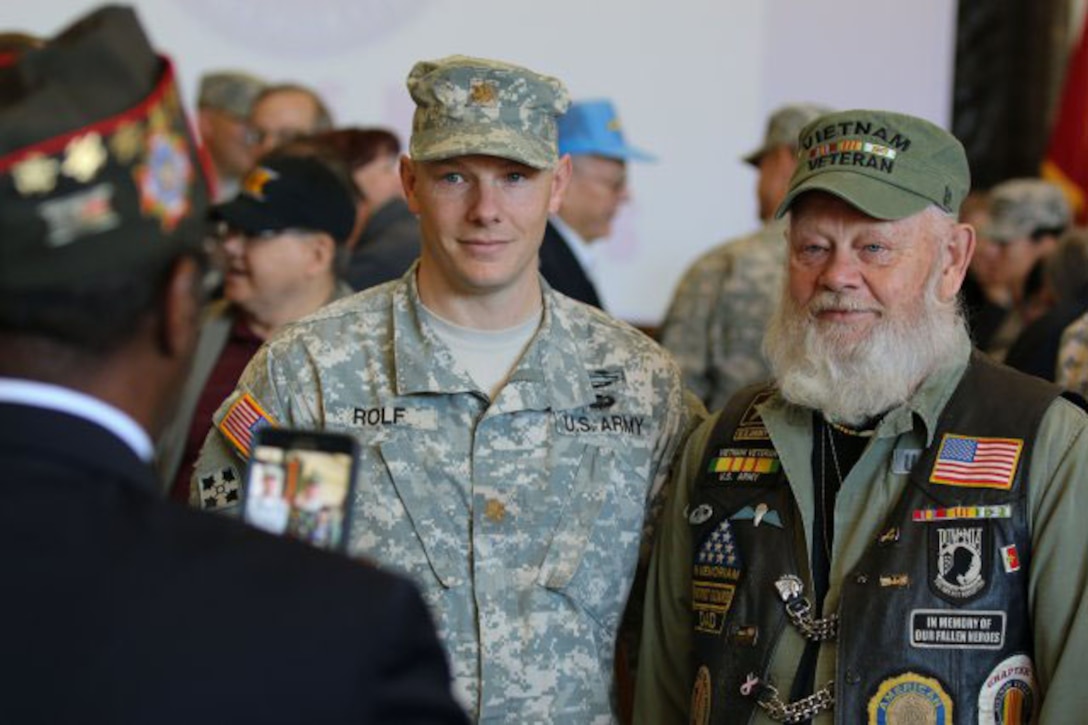 Army Maj. Zach Rolf poses for a photo with his father and Vietnam War veteran, Lynn Rolf, after the Vietnam Veterans Welcome Home ceremony at Fort Riley's Marshall Army Airfield, KS. Nov. 6, 2015.