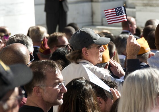 An audience member holds a U.S. flag during the National Veterans Day Observance at Arlington National Cemetery in Arlington, Va., on Nov. 11, 2015. (U.S. Air Force photo/Sean Kimmons)