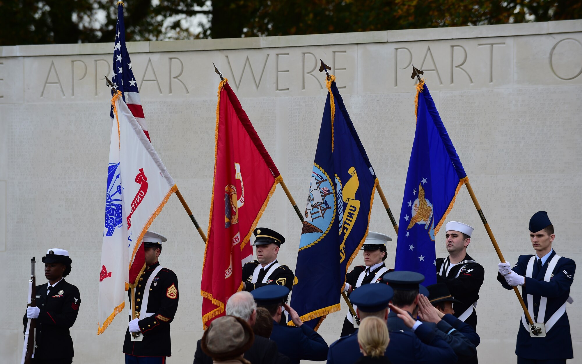 Members of the Joint Services honor guard present the colors during a Veterans Day ceremony at Cambridge American Cemetery, United Kingdom, Nov. 11, 2015. The ceremony honored both the 3,812 American Service members buried at the cemetery, along with veterans, past and present. (U.S. Air Force photo by Master Sgt. Chrissy Best/Released))