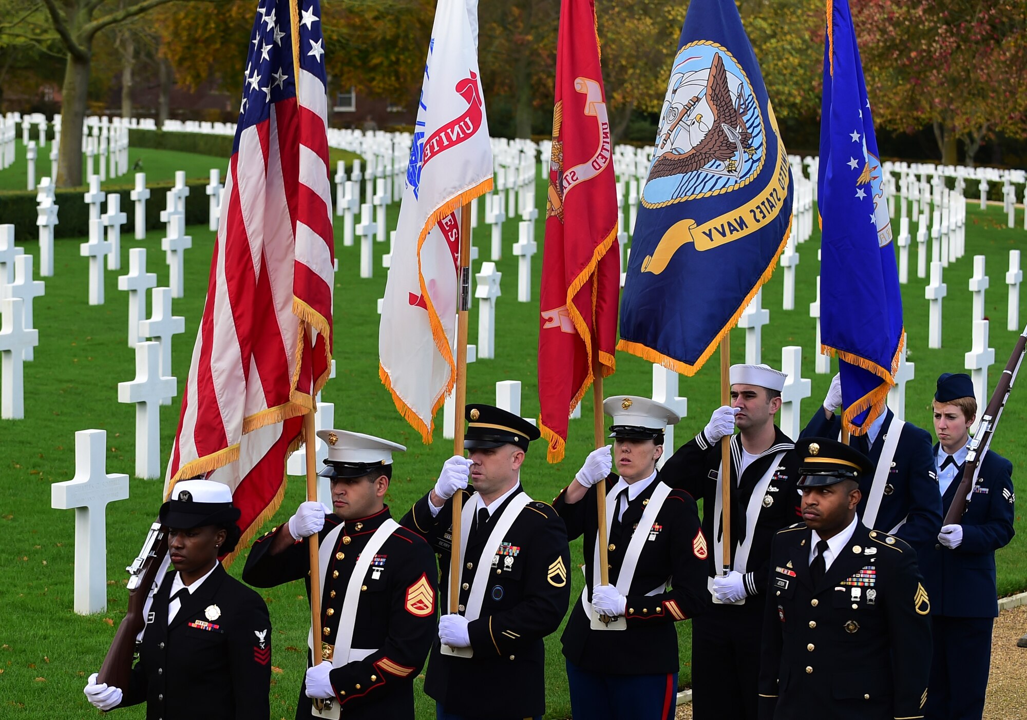 Members of the Joint Services honor guard prepare to present the colors during a Veterans Day ceremony at Cambridge American Cemetery, United Kingdom, Nov. 11, 2015. The ceremony honored both the 3,812 American Service members buried at the cemetery, along with veterans, past and present. (U.S. Air Force photo by Master Sgt. Chrissy Best/Released)
