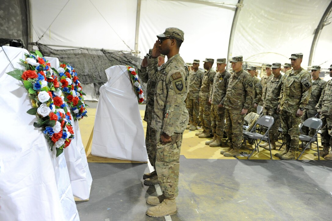U.S. troops render honors in a wreath-laying ceremony during a Veterans Day observance on Bagram Airfield, Afghanistan, Nov. 11, 2015. U.S. Army photo by Vanessa Villarreal
