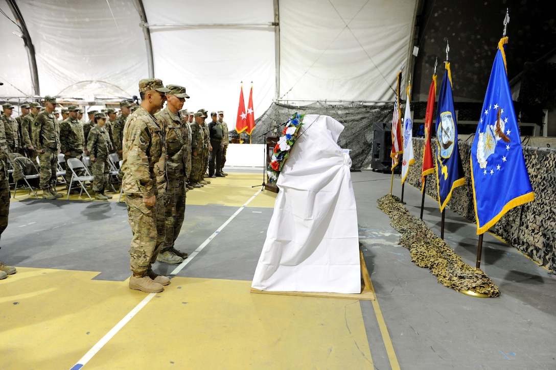 U.S. troops pause for a moment of silence during a wreath laying as service members and civilians participate in a Veterans Day ceremony on Bagram Airfield, Afghanistan, Nov. 11, 2015. U.S. Army photo by Vanessa Villarreal