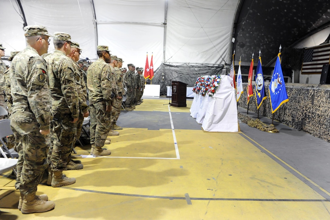 U.S. troops pause for a moment of silence during a wreath-laying ceremony as service members and civilians observe Veterans Day on Bagram Airfield, Afghanistan, Nov. 11, 2015. U.S. Army photo by Vanessa Villarreal