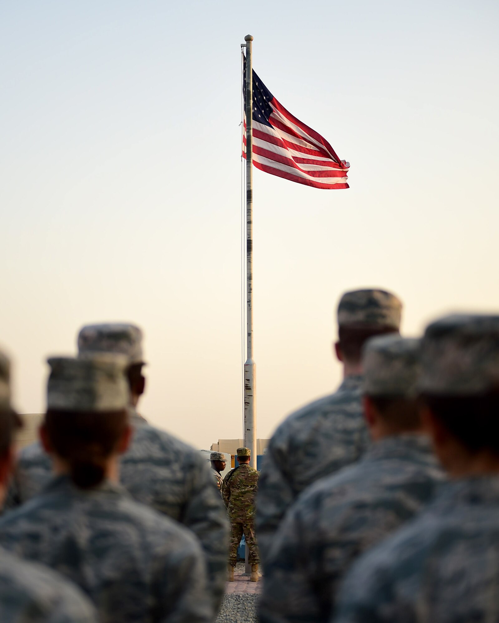 Airmen from the 386th Air Expeditionary Wing standby for the playing of the national anthem during a Veteran’s Day retreat at an undisclosed location in Southwest Asia, Nov. 11, 2015. Veteran’s Day serves as a day to remember and honor the service and sacrifices made by those in the Armed Forces. (U.S. Air Force photo by Staff Sgt. Jerilyn Quintanilla) 