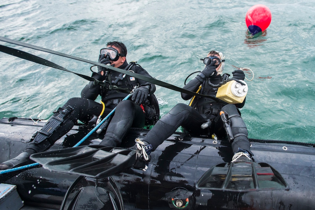 Navy Petty Officer 3rd Class Corey Barker, right, and Seaman John Dirks enter the water during Exercise Clear Horizon on Commander Fleet Activities Chinhae in Chinhae, South Korea, Nov. 12, 2015. The annual exercise between the U.S. and South Korean navies focuses on increasing capabilities between ship, and on mine countermeasures in international waters surrounding the Korean peninsula. Barker and Dirks are assigned to Explosive Ordnance Disposal Mobile Unit 5. U.S. Navy photo by Petty Officer 2nd Class Daniel Rolston