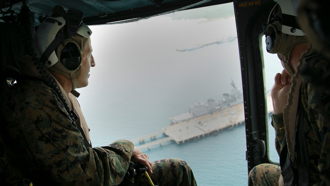 Lt. Gen. Michael G. Dana observes Naval Facility White Beach piers from a UH-1Y Huey helicopter during an air tour Nov. 5 on Okinawa, Japan. Marines use the facility in order to board amphibious shipping to deploy throughout the region. The air tour also allowed Dana to view other strategic access points on Okinawa, as well as the strategic resources and high readiness of Marine Corps Installations Pacific camps and facilities in daily support of operations across the Indo-Asia-Pacific region. The visit also drew attention to the importance of financial and manpower resources within MCIPAC. Dana is the deputy commandant for installations and logistics.