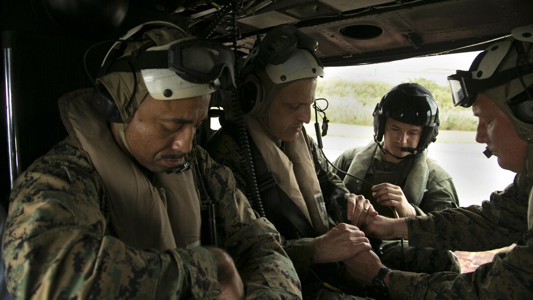 Lt. Gen. Michael G. Dana, left center, and Brig. Gen. Tracey W. King, far right, prepare for an air tour aboard a UH-1Y Huey helicopter Nov. 5 on Camp Courtney, Okinawa, Japan. The air tour allowed Dana to view strategic access points on Okinawa, as well as the strategic resources and high readiness of Marine Corps Installations Pacific camps and facilities in daily support of operations across the Indo-Asia-Pacific region. The visit also drew attention to the importance of financial and manpower resources within MCIPAC. Dana is the deputy commandant for installations and logistics. King is the commanding general of the 3rd Marine Logistics Group, III Marine Expeditionary Force.