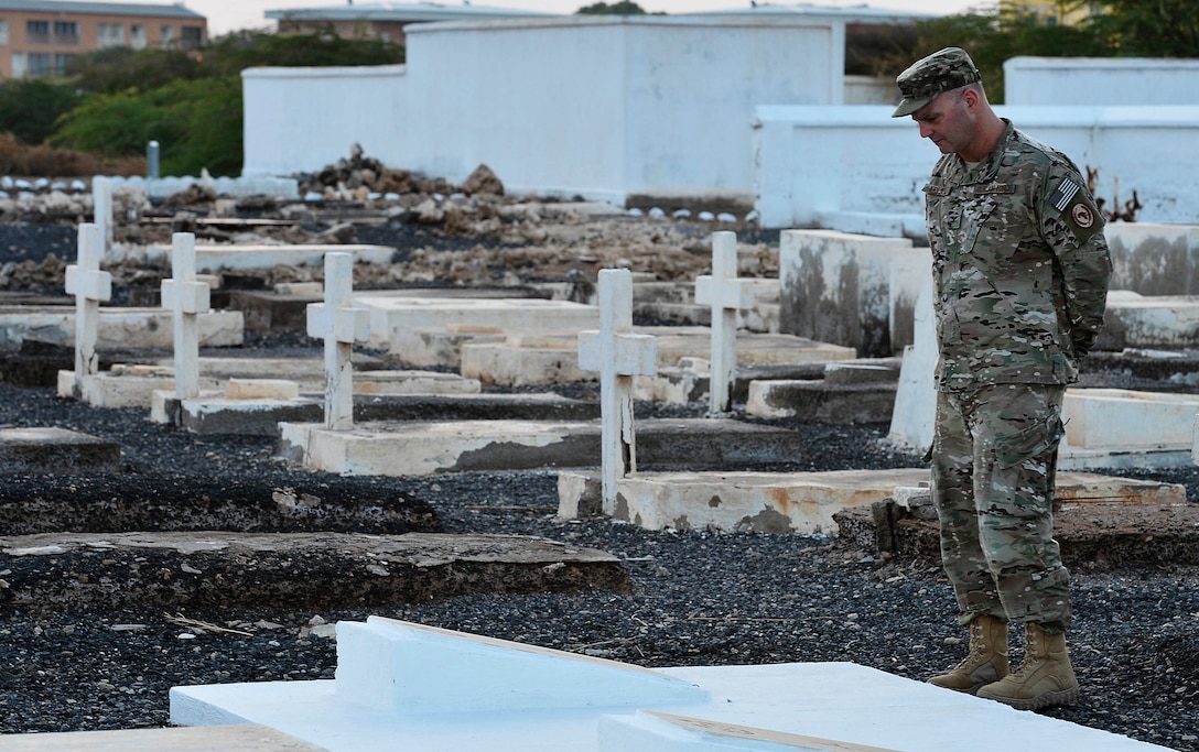 U.S. Air Force Col. James Kriesel, chief of staff for the Combined Joint Task Force-Horn of Africa, reads the gravestone of Lawrence R. Maguire, a pilot officer, during a Remembrance Day service near Camp Lemonnier, Djibouti, Nov. 11, 2015. Although a U.S. citizen, Maguire joined the Canadian air force during World War II and was the first Canadian airman killed in the African theater of operations. U.S. Air Force photo by Tech. Sgt. Dan DeCook