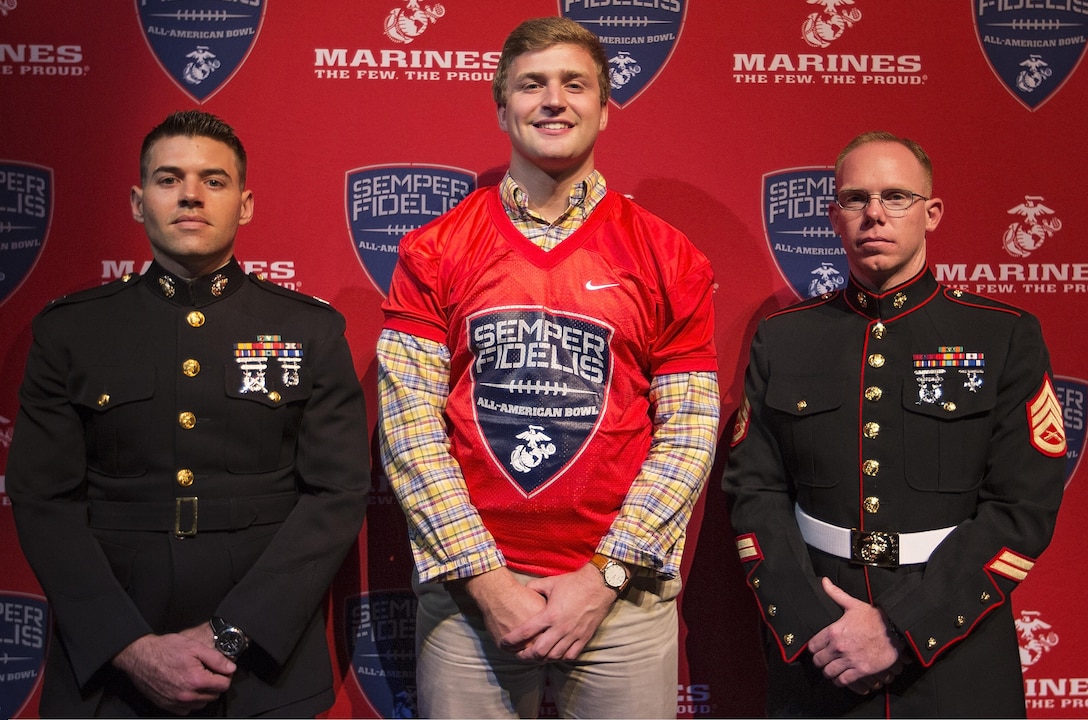 JC Chalk, football player for Argyle High School, stands with Capt. Vince Margiotta, Executive Officer for Recruiting Station Fort Worth and Staff Sgt. Clayton Brand, recruiter at Recruiting Sub-Station Denton, RS Fort Worth after being presented a Semper Fi Bowl Jersey. Players selected are well-rounded individuals, not only are they distinguished athletes, but also have academic achievements and display exemplary moral characteristics. (U.S. Marine Corps photo by Sgt. Rebecca Eller)