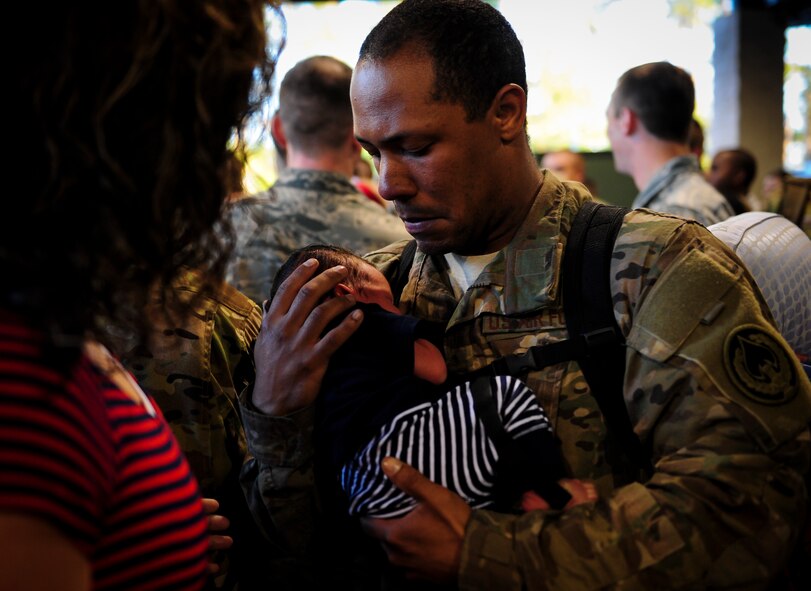 Staff Sgt. Michael Mayo, a communications navigator craftsman with the 4th Special Operations Squadron, holds his newborn for the first time during Operation Homecoming at Hurlburt Field, Fla., Nov. 6, 2015. Air Commandos with the 4th Special Operations Squadron returned from deployment to their friends and family. (U.S. Air Force photo by Senior Airman Meagan Schutter)