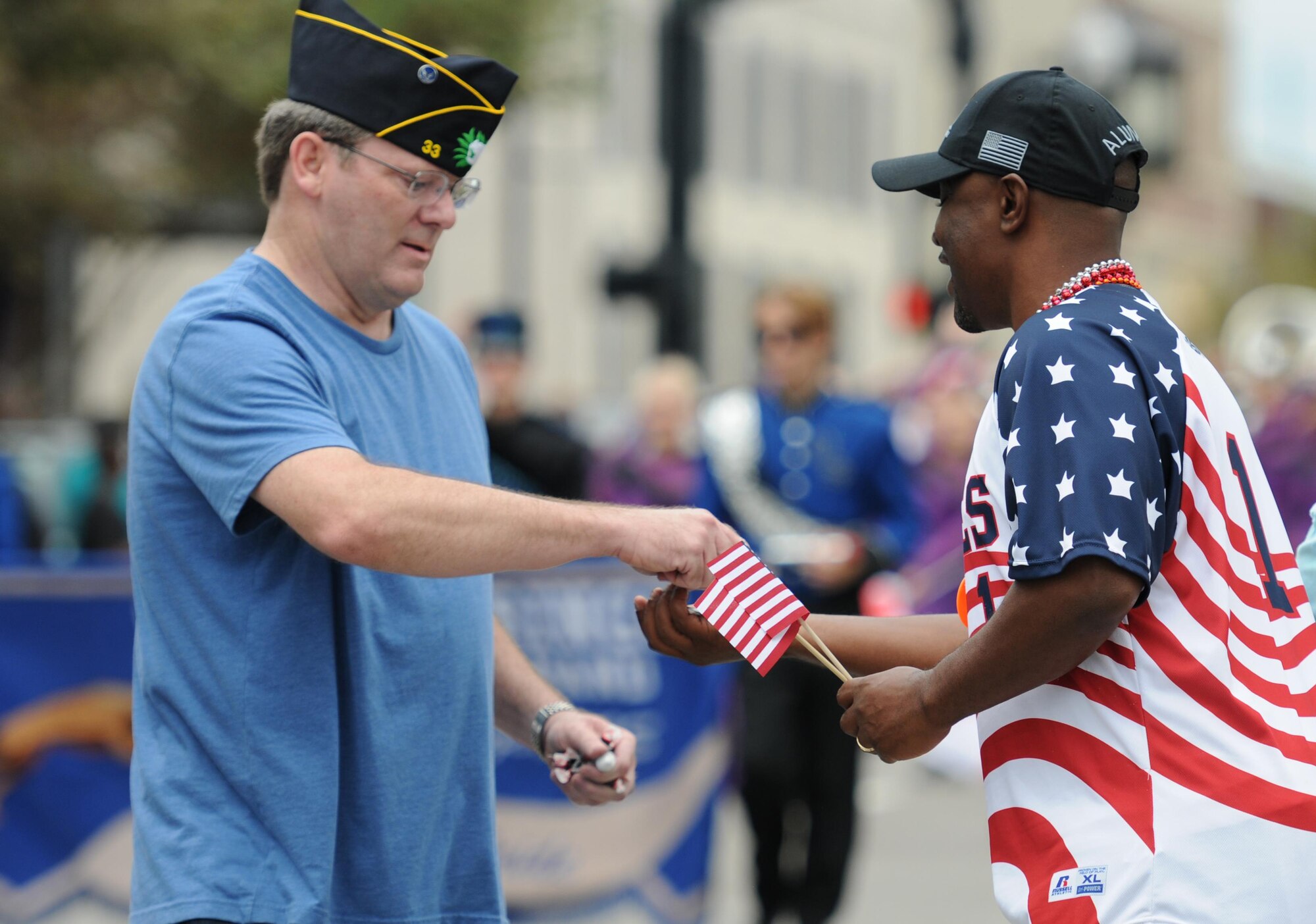 Kenneth Dodd, 81st Training Wing historian, Keesler Air Force Base, Miss., passes candy to retired Army Sgt. 1st Class Shawn Owens during the 15th Annual Gulf Coast Veterans Day Parade Nov. 7, 2015, in Gulfport, Miss. Keesler’s 81st Training Wing leadership, Honor Guard, 81st Training Group’s Drum and Bugle Corps, and Airmen participated in the event. (U.S. Air Force photo by Kemberly Groue)