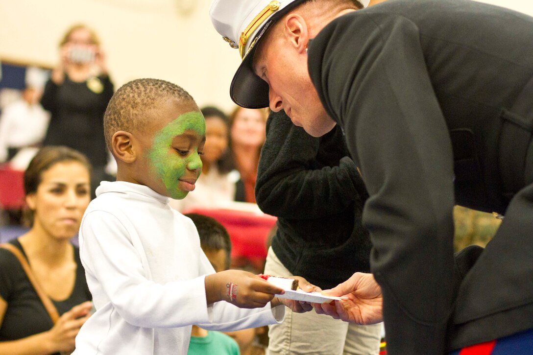 Xavier, 3, is honored as the youngest military child present during the cake cutting of the Military Kids Birthday Bash Nov. 5 at the Barber Physical Fitness Center. His mother is a sergeant in the Headquarters and Support Battalion.