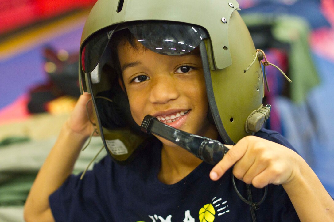 Maum, 6, plays dress up with an authentic aviation helmet during the Military Kids Birthday Bash Nov. 5 at the Barber Physical Fitness Center.