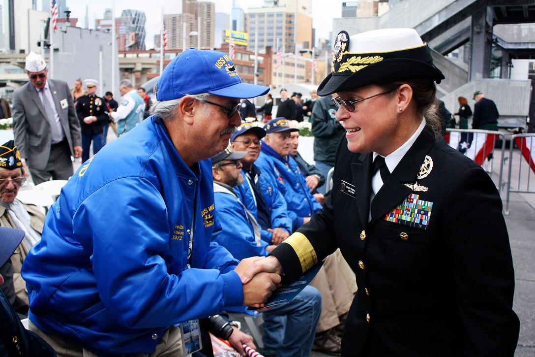 Navy Rear Adm. Cynthia M. Thebaud, right, commander Expeditionary Strike Group 2, greets a veteran during a Veterans Day ceremony outside the Intrepid Sea, Air and Space Museum Complex in New York, Nov. 11, 2015. U.S. Navy photo by Lt. Joseph Olivares