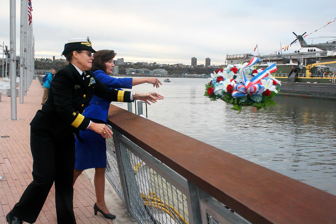 Navy Rear Adm. Cynthia M. Thebaud, foreground, commander Expeditionary Strike Group 2, and New York Lieutenant Governor Kathleen Hochul, toss a wreath into the Hudson River outside the Intrepid Sea, Air and Space Museum Complex in New York, Nov. 11, 2015. U.S. Navy photo by Lt. Joseph Olivares