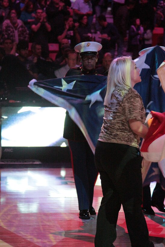 Master Gunnery Sgt. Charles Melvin, II, recruiter instructor, Recruiting Station Sacramento, folds the flag during the opening ceremony of the Sacramento Kings vs. Detroit Pistons game and Veterans Day celebration at the Sleep Train Arena in Sacramento, Nov. 11, 2015.