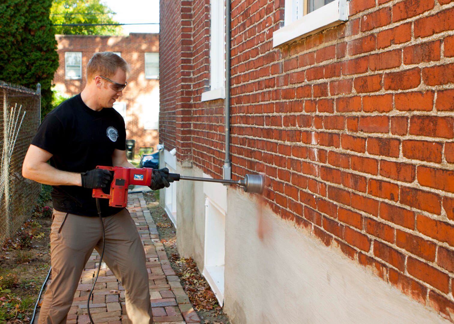 Army Staff Sgt. David Lewis, a parachute rigger assigned to DLA Distribution Susquehanna, Pa., works to cut a dryer vent in the side of a home as part of a project with Habitat for Humanity to rehab a home for a local veteran.