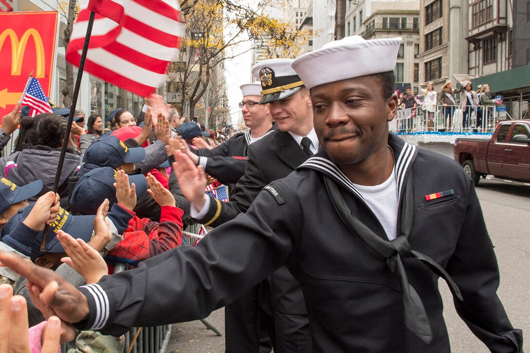 Sailors assigned to the USS New York greet veterans and well-wishers while marching in the 2015 New York City Veterans Day Parade in New York, Nov. 11, 2015. U.S. Navy photo by Petty Officer 1st Class Brian McNeal