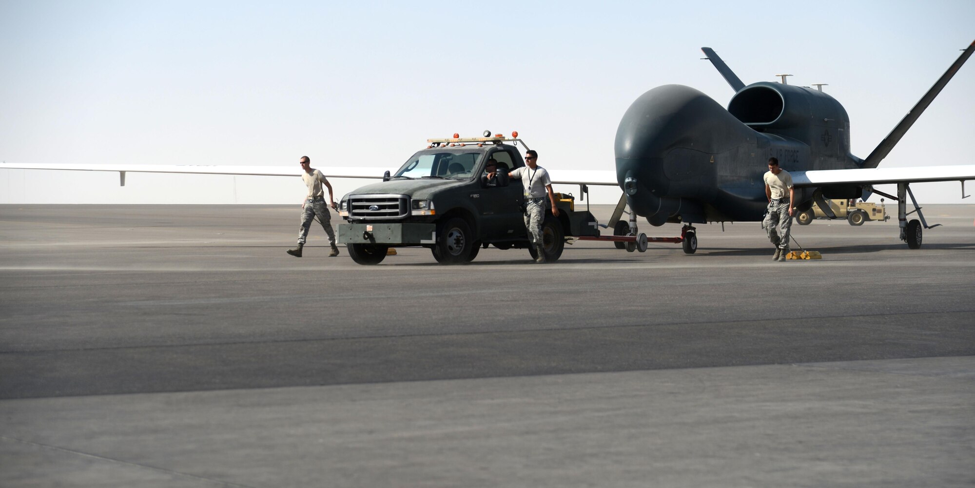 U.S. Airmen assigned to the 380th Expeditionary Aircraft Maintenance Squadron perform recovery operations for an EQ-4 Global Hawk unmanned aircraft at an undisclosed location in Southwest Asia, Nov. 11, 2015. Once the Global Hawk’s mission is complete it returns home where maintainers are able to perform ground maintenance within five hours to return the aircraft to mission ready status. (U.S. Air Force photo by Tech. Sgt. Frank Miller/Released)