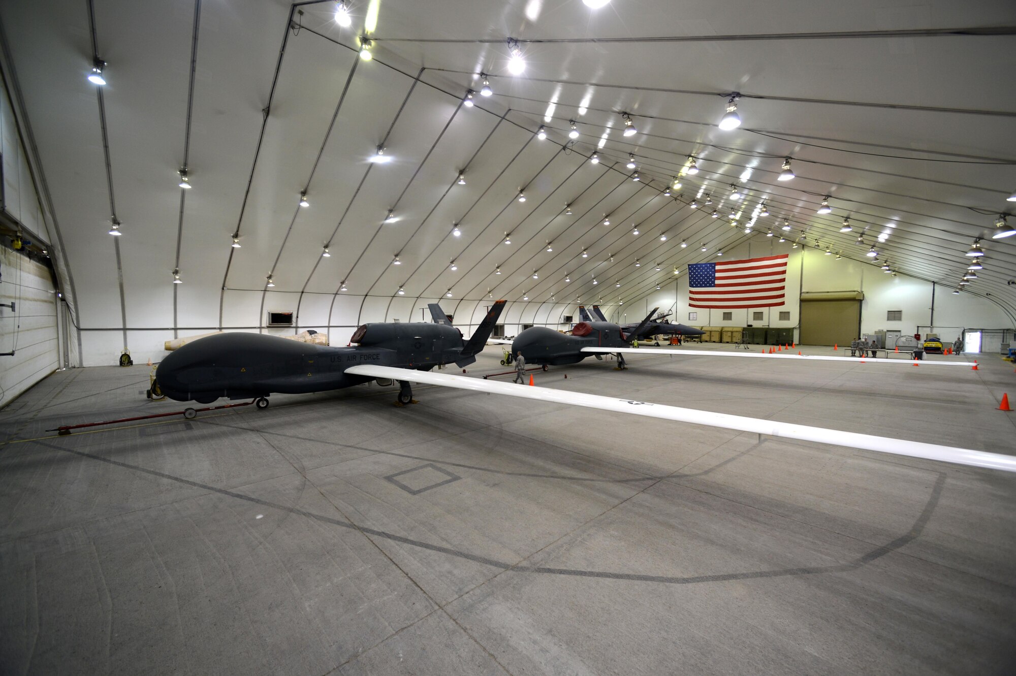 U.S. Air Force EQ-4 Global Hawk unmanned aircraft is positioned in front of an RQ-4 Global Hawk at an undisclosed location in Southwest Asia, Nov. 11, 2015.Three RQ-4 Global Hawks were converted to an EQ-4 relay configuration carrying the Battlefield Airborne Communication Node (BACN) in 2009.  (U.S. Air Force photo by Tech. Sgt. Frank Miller/Released)