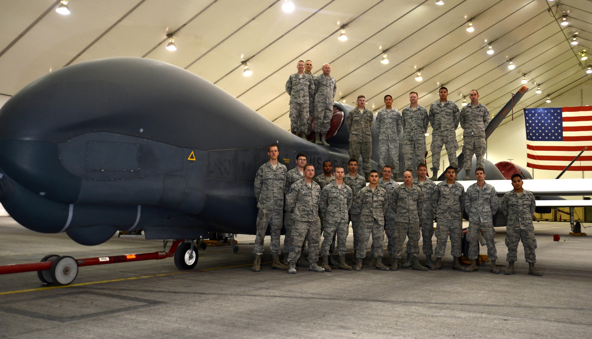 U.S. Airmen assigned to the 380th Expeditionary Aircraft Maintenance Squadron stand next to ‘Workhorse’ an EQ-4 Global Hawk unmanned aircraft at an undisclosed location in Southwest Asia, Nov. 11, 2015. The Global Hawk marked history when it landed for its 500 sortie milestone, and with nearly 13,000 flight hours logged, this weapon system is lived up to the nickname “Workhorse”. (U.S. Air Force photo by Tech. Sgt. Frank Miller/Released)