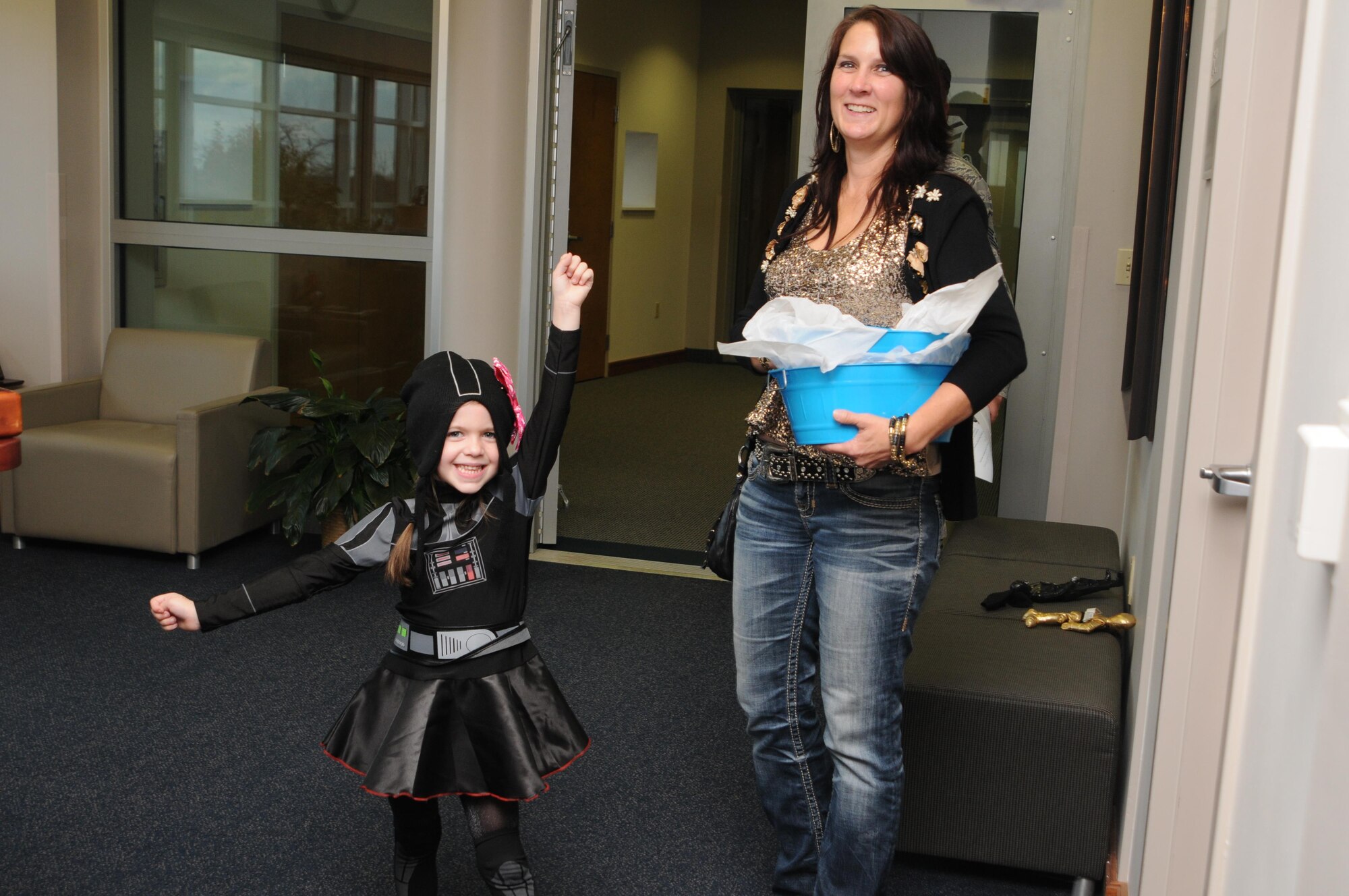 USO Volunteer Patricia Reed and a young girl wearing a Darth Princess costume deliver a bucket of candy to the 910th Airlift Wing during the Unit Training Assembly here, Nov. 7, 2015. The duo made their rounds delivering candy buckets around the air station on behalf of the USO of Northern Ohio. The USO Lounge at YARS is the only one at a reserve station in the continental United States. For more information about the USO, visit www.uso.org. (U.S. Air Force photo/Staff Sgt. Rachel Kocin)